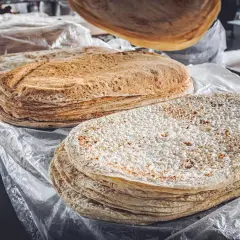 Stosy cienkiego, okrągłego pieczywa, w tym lawasz, co to jest? Idealne do zawijania smakołyków.