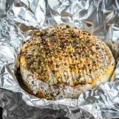 Pyszny camembert z grilla, otulony folią aluminiową, posypany ziołami i przyprawami. Idealny na letnie wieczory.