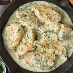 Soczysta pierś z kurczaka w kremowym sosie koperkowym, podana w żeliwnej patelni. Aromatyczne danie, które zachwyca smakiem.