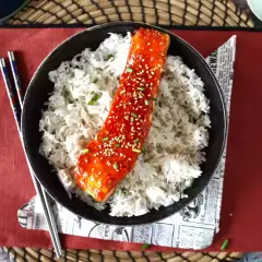 Łosoś w sosie gochujang z sezamem i ryżem, podany z pałeczkami.