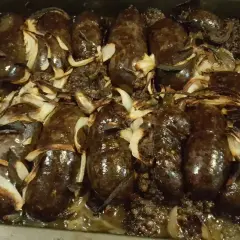 Kaszanka z grilla z cebulą w folii aluminiowej, pieczona do perfekcji. Aromatyczna i soczysta, gotowa do podania.