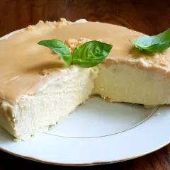 Puszysty keto sernik na zimno z delikatną polewą karmelową i listkami bazylii. Idealny deser dla miłośników niskowęglowodanowych słodkości.