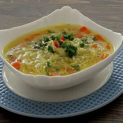 Aromatyczna zupa na rosole z makaronem nitki i marchewką, udekorowana natką pietruszki. Idealna na chłodne dni.