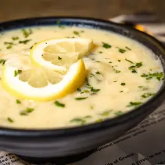 Aksamitna zupa cytrynowa, ozdobiona plasterkami cytryny i posypana natką pietruszki, kusi swoim aromatem.