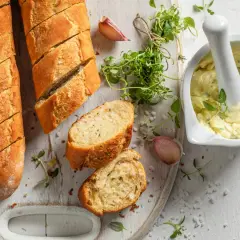 Chrupiące bagietki z masłem czosnkowym, świeże zioła i czosnek – idealny przepis na pyszne pieczywo.