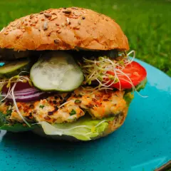 Pyszne burgery z grilla z chrupiącą bułką, soczystym kotletem, świeżymi warzywami i kiełkami.