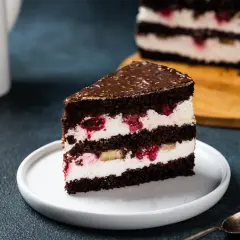 Kawałek czekoladowego tortu z kremem mascarpone, malinami i bananem. Idealny, bardzo łatwy tort z mascarpone na deser.