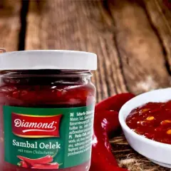 Słoiki z pikantnym sosem Sambal Oelek, z widocznymi papryczkami chili. Idealny do potraw, które potrzebują odrobiny ostrości.
