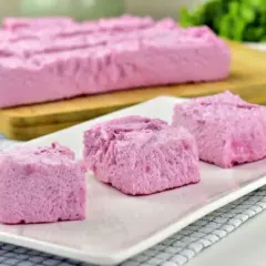 Różowa pianka z galaretki i jogurtu, pocięta na kostki, prezentuje się lekko i puszysto.