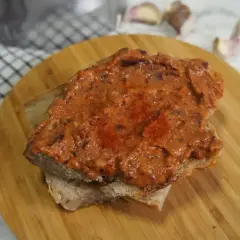 Pyszna pasta z czerwonej fasoli na kromce chleba, posypana papryką. Idealna na szybką przekąskę.