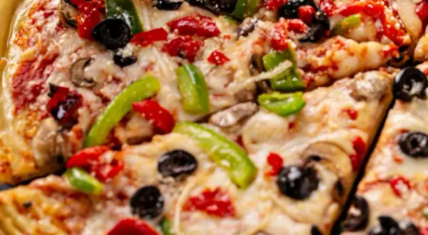 Pyszna pizza z serka wiejskiego, z pieczarkami, papryką i oliwkami. Idealna na szybki obiad.