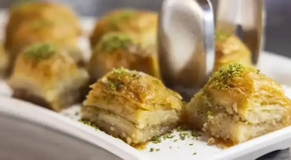 Słodka baklava, co to? Warstwy ciasta filo, orzechów i syropu, posypane pistacjami. Pyszny deser.