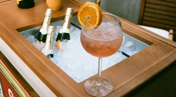 Orzeźwiający Aperol z pomarańczą i butelkami prosecco w lodzie. Idealne na lato, zastanawiasz się jakie prosecco do Aperola?