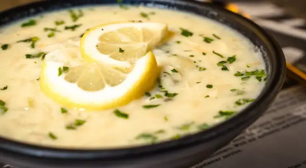 Aksamitna zupa cytrynowa, ozdobiona plasterkami cytryny i posypana natką pietruszki, kusi swoim aromatem.