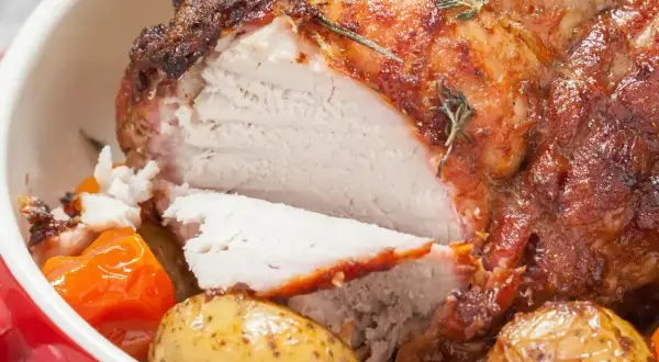 Soczysty schab pieczony w piekarniku w naczyniu, podany z ziemniakami i marchewką.