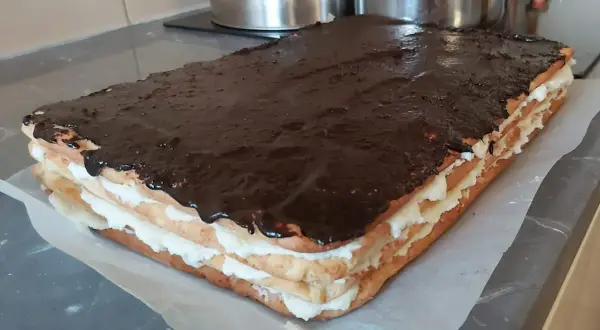 Pyszny, prostokątny tort Stefania z kremem i polewą czekoladową, gotowy do podania.