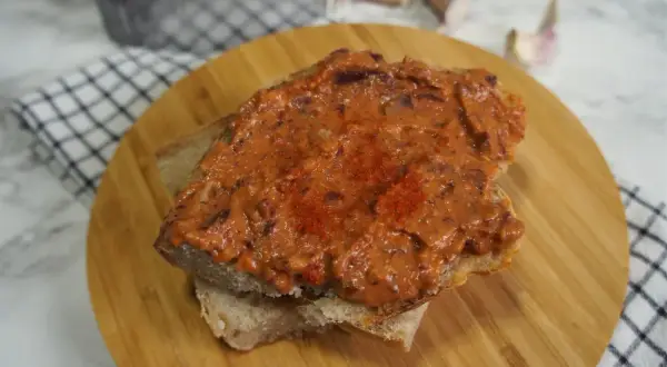 Pyszna pasta z czerwonej fasoli na kromce chleba, posypana papryką. Idealna na szybką przekąskę.