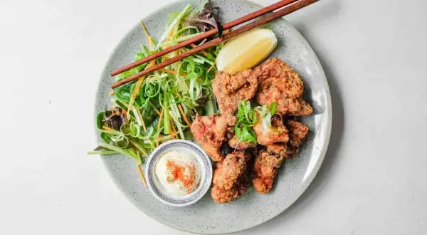 Chrupiący kurczak karaage z sałatką i dipem. Pałeczki czekają, by zacząć ucztę.