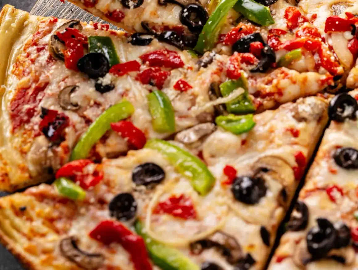 Pyszna pizza z serka wiejskiego, z pieczarkami, papryką i oliwkami. Idealna na szybki obiad.