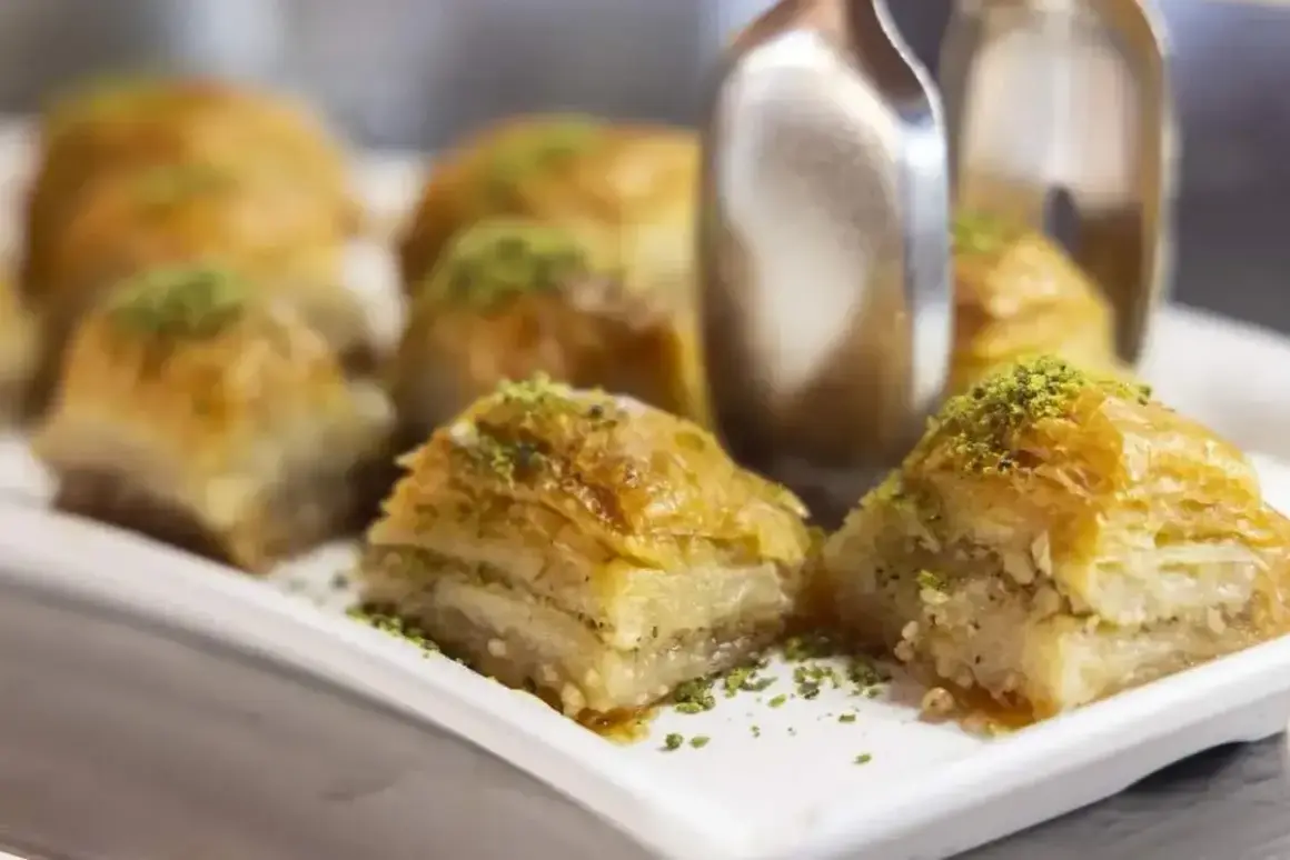 Słodka baklava, co to? Warstwy ciasta filo, orzechów i syropu, posypane pistacjami. Pyszny deser.