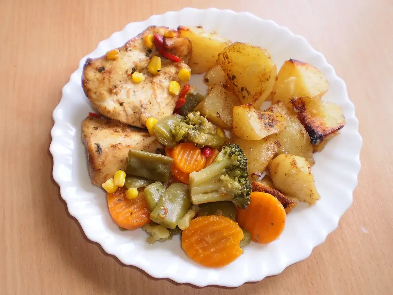 Pyszny filet z kurczaka z piekarnika podany z pieczonymi ziemniakami, brokułami, marchewką i fasolką szparagową.