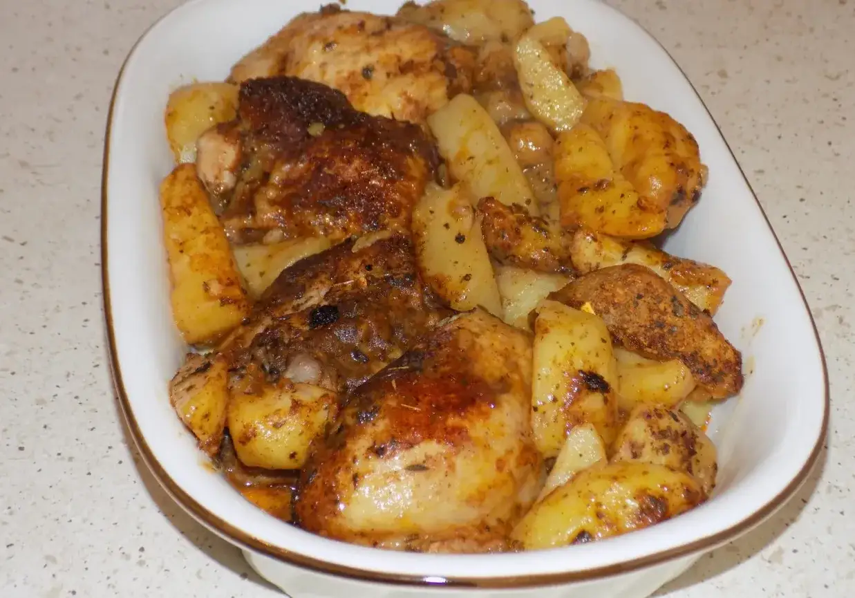 Pyszne udka z kurczaka pieczone z ziemniakami, wszystko skąpane w aromatycznej marynacie. Idealne na obiad!