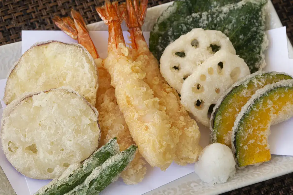 Talerz pełen chrupiącego tempura: krewetki, bataty, dynia, lotos, fasolka i liście. To jest właśnie tempura co to!