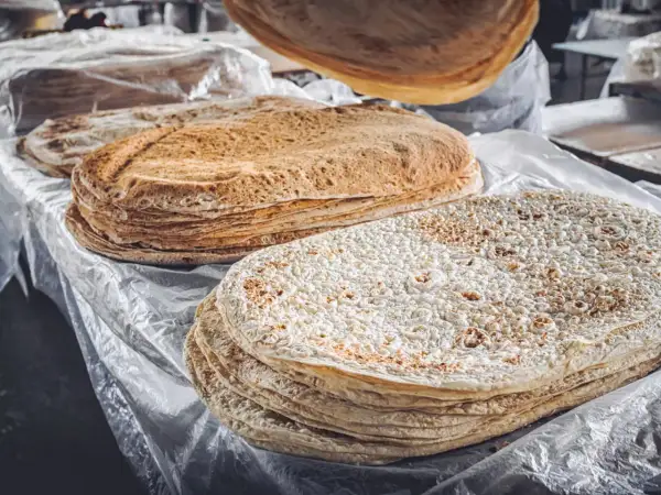 Stosy cienkiego, okrągłego pieczywa, w tym lawasz, co to jest? Idealne do zawijania smakołyków.