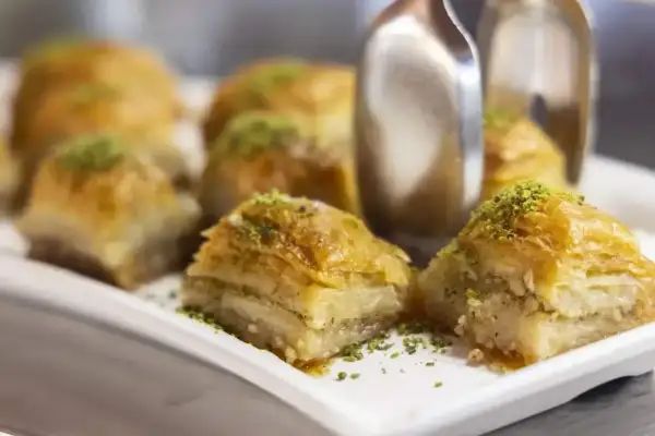 Słodka baklava, co to? Warstwy ciasta filo, orzechów i syropu, posypane pistacjami. Pyszny deser.