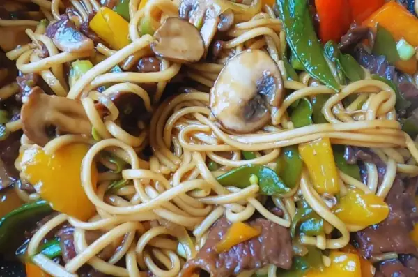Pyszny makaron udon z wołowiną, pieczarkami i kolorową papryką. Idealny przepis na szybki obiad.
