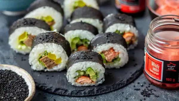 Pyszne domowe sushi z łososiem i awokado, gotowe do podania z imbirem i sezamem.