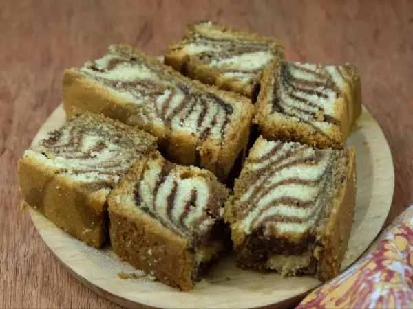 Kawałki ciasta zebra, przygotowane według starego przepisu, ułożone na drewnianej desce.
