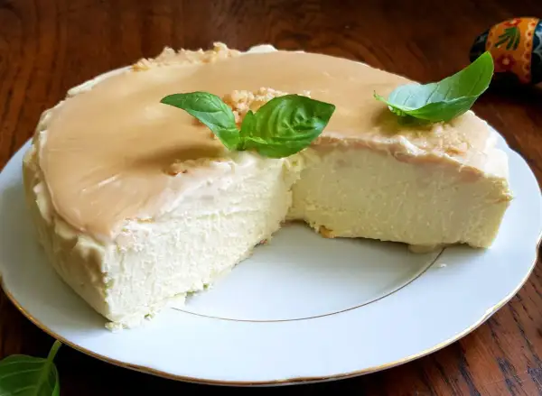 Puszysty keto sernik na zimno z delikatną polewą karmelową i listkami bazylii. Idealny deser dla miłośników niskowęglowodanowych słodkości.