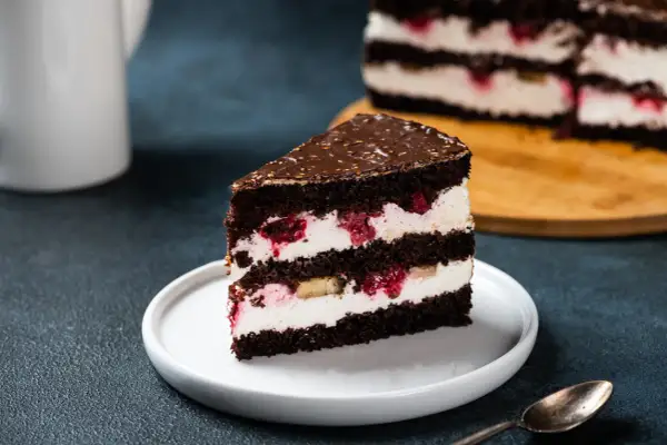 Kawałek czekoladowego tortu z kremem mascarpone, malinami i bananem. Idealny, bardzo łatwy tort z mascarpone na deser.