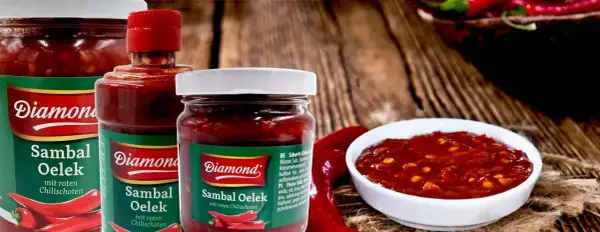 Słoiki z pikantnym sosem Sambal Oelek, z widocznymi papryczkami chili. Idealny do potraw, które potrzebują odrobiny ostrości.