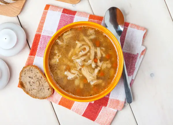Stary przepis na flaki po zamojsku. Aromatyczna zupa z kawałkami flaków i marchewki, podana z chlebem.